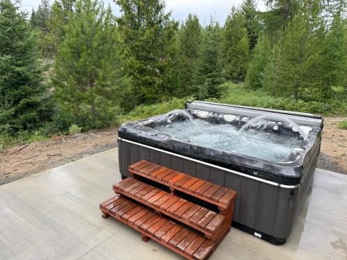 a hot tub sitting on a patio next to a bench at North Haven Campground in Bonners Ferry