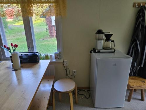 a kitchen with a counter and a refrigerator and a table at Merikarviantupa in Pori