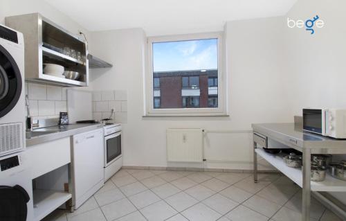 a kitchen with white appliances and a window at BEGE APARTMENTS WorkPoint in Dorsten