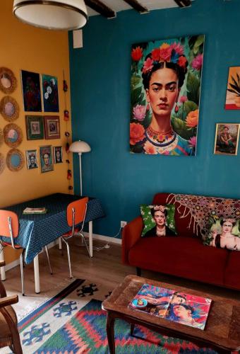 a living room with a couch and a painting on the wall at The Frida in Sillé-le-Guillaume