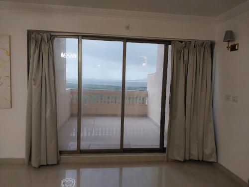 a room with a large glass window with a view at Outstay Executive Apartments in Navi Mumbai