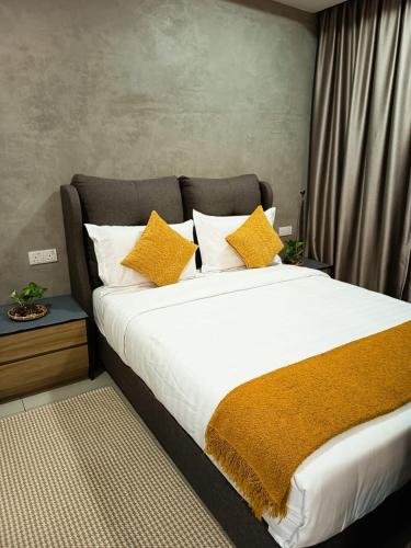 Un dormitorio con una cama grande con almohadas amarillas. en Cozy Haven Middlemist's Red Suite at Trefoil, en Shah Alam