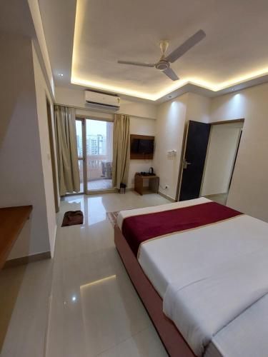a bedroom with two beds and a ceiling fan at Outstay Executive Apartments in Navi Mumbai