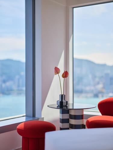 a room with two red chairs and a table and a window at Mondrian Hong Kong in Hong Kong