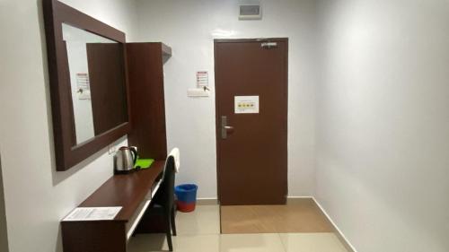 a bathroom with a brown door and a mirror at Codidik Hotel in Kuantan