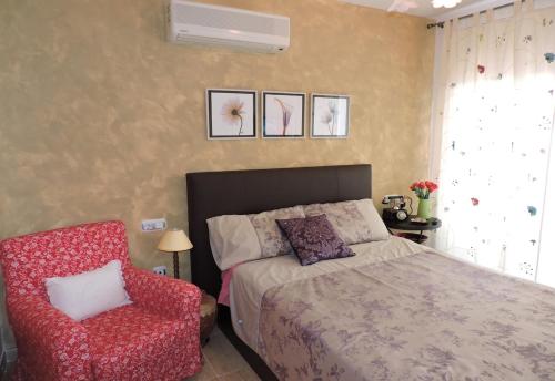 una camera da letto con un letto e una sedia rossa di Lcd - Alfons I a Montroig