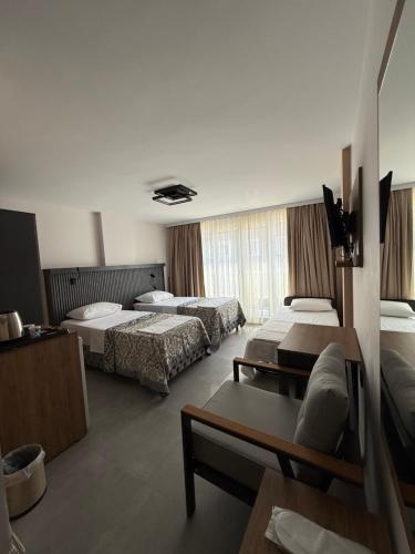 a hotel room with two beds and a couch at D'Premium Hotel in Edirne