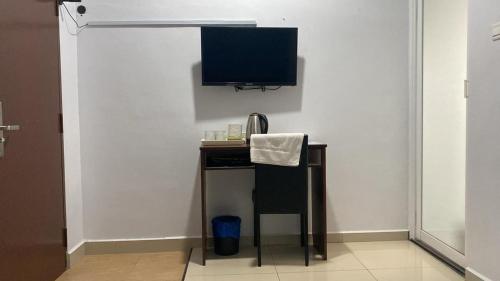 a room with a desk with a television on a wall at Codidik Hotel in Kuantan