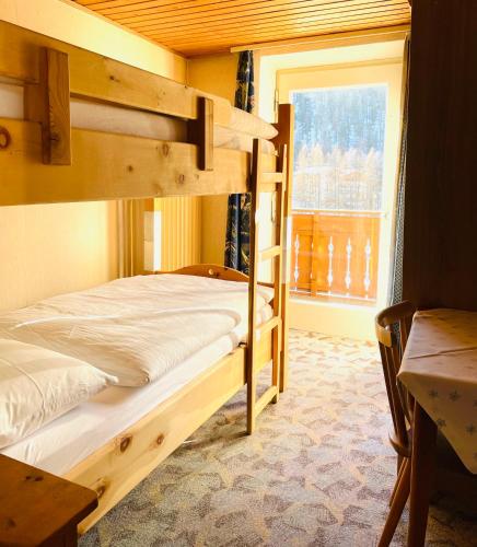 a bedroom with two bunk beds and a window at Glacier Rock guesthouse ex Pension Dangl in Solda