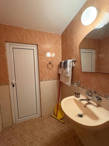 a bathroom with a sink and a mirror and a mop at Sarievi Holiday Home in Tsarevo