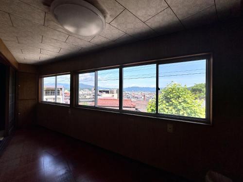 an empty room with windows and a view of a city at AOI SHIROYAMA 3-minute walk to the old streets of Hida Takayama in Takayama
