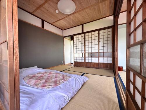 a bedroom with a bed in a room with a wall at AOI SHIROYAMA 3-minute walk to the old streets of Hida Takayama in Takayama