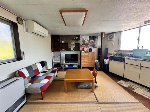 a living room with a couch and a table at AOI SHIROYAMA 3-minute walk to the old streets of Hida Takayama in Takayama