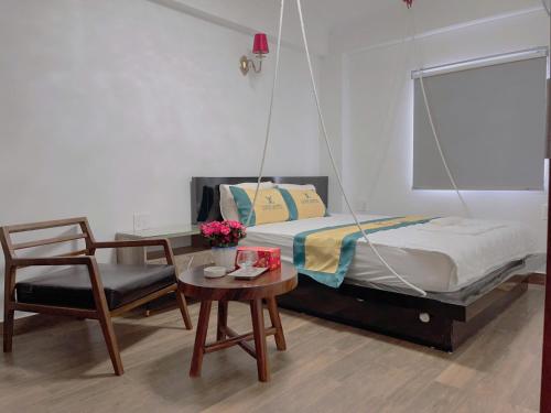 a bedroom with a swing bed and a table and a chair at Love Hotel Hóc Môn in Ho Chi Minh City