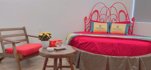 a bedroom with a bed and a chair and a table at Love Hotel Hóc Môn in Ho Chi Minh City