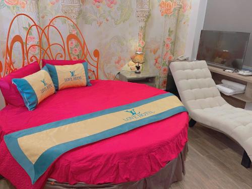 a bedroom with a large bed and a chair at Love Hotel Hóc Môn in Ho Chi Minh City