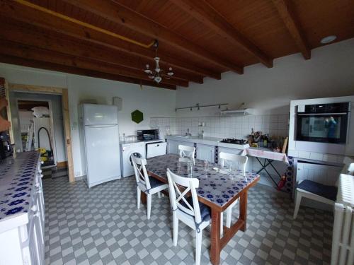 una cucina con tavolo, sedie e frigorifero di Un Détour Par Thiénans cottage entier 