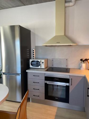 a kitchen with a stove and a microwave at Casa Angel Isora in Isora