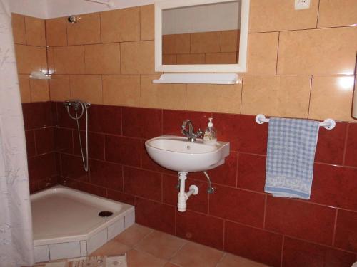La salle de bains est pourvue d'un lavabo et d'une baignoire. dans l'établissement Fenyves Apartman, à Sárospatak