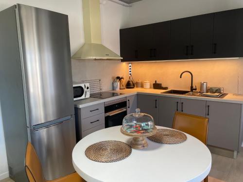 a kitchen with a white table and a silver refrigerator at Casa Angel Isora in Isora