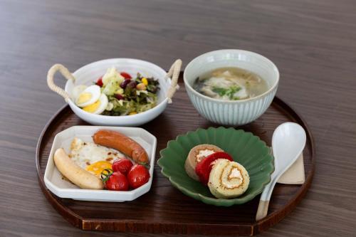 a tray with three dishes of food and a bowl of soup at Yi Nian · Fangcun Hotel in Nanchang