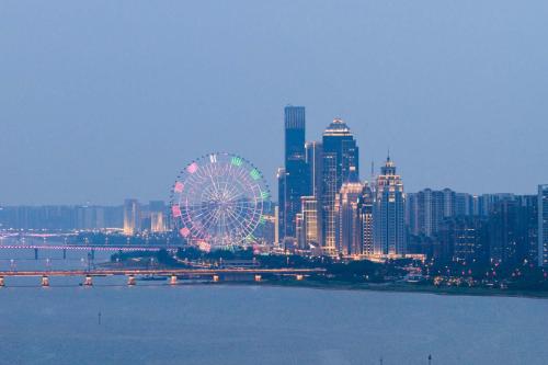 a large ferris wheel in front of a large city at Yi Nian · Fangcun Hotel in Nanchang