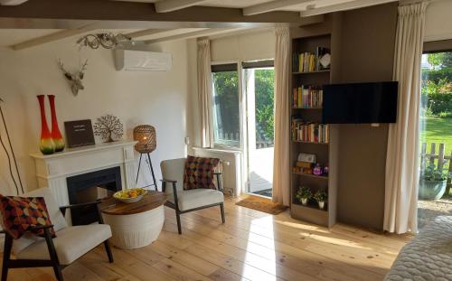 a living room with a fireplace and a tv at Bed and Breakfast Hattem in Hattem