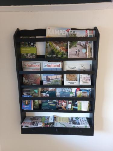 a book shelf filled with magazines and newspapers at Bed and Breakfast Hattem in Hattem