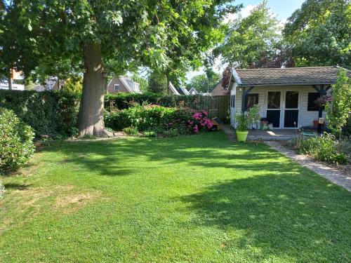 a yard with a tree and a house at Bed and Breakfast Hattem in Hattem