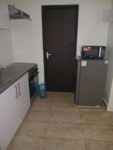 a kitchen with a black door and a refrigerator at 1255 Palm Ridge Estate in Vipingo