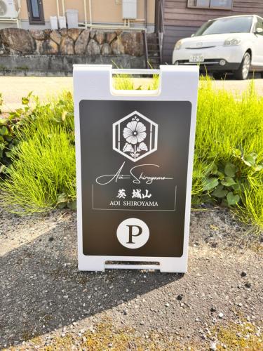 a sign sitting on the side of a street at AOI SHIROYAMA 3-minute walk to the old streets of Hida Takayama in Takayama