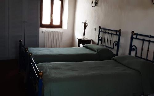 two twin beds in a room with a window at Celle di Lecchi Vigneto in San Sano