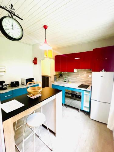 une cuisine avec des placards rouges et une horloge au plafond dans l'établissement Close to the Lake !!!, à Gérardmer