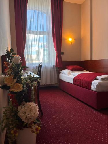 a hotel room with a bed and a window at Hotel Continental in Plzeň