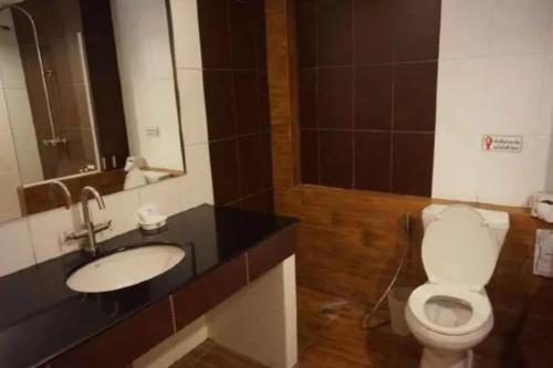 a bathroom with a toilet and a sink and a mirror at Tonwa Resort Hotel in Khon Kaen