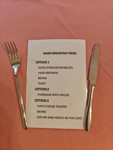 a menu with a fork and knife on a table at The Jays Guest House in Aberdeen