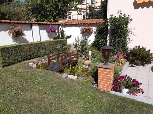 a garden with a bench and flowers in a yard at Ferienwohnung Zum Steiger in Bleicherode