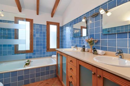 a blue tiled bathroom with a tub and a sink at Riu Rau in Jávea