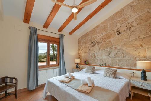 a bedroom with a bed and a stone wall at Riu Rau in Jávea