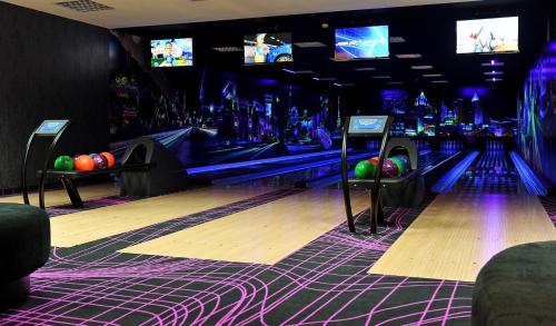 a bowling alley with pins and televisions in a room at Hotel Sękowski in Legnica