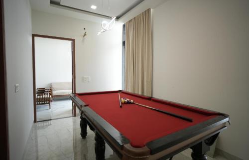 a red pool table in a room with a mirror at Angelo's farm in Jaipur