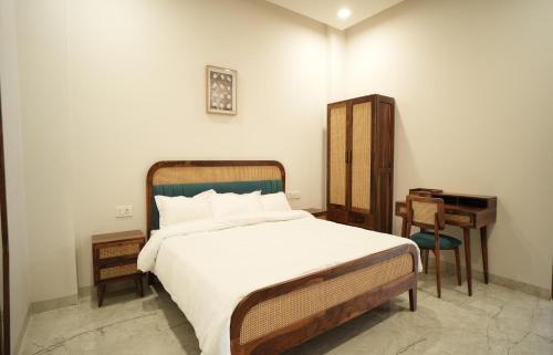 a bedroom with a large bed with a desk and a bed sidx sidx sidx at Angelo's farm in Jaipur