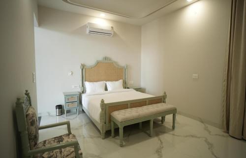 a bedroom with a bed and a bench in it at Angelo's farm in Jaipur