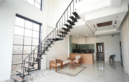 a spiral staircase in a living room with a table and chairs at Angelo's farm in Jaipur