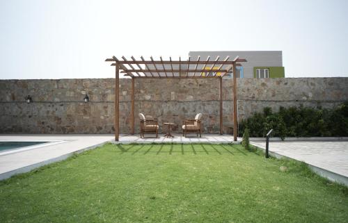 a patio with a table and chairs under a pergola at Angelo's farm in Jaipur