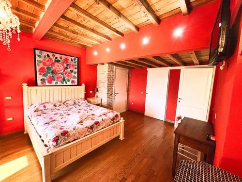 a bedroom with red walls and a bed and a table at Nonna Nara Bed & Breakfast in Grosseto