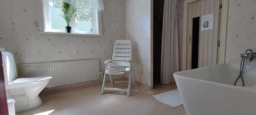 a bathroom with a white tub and a chair in it at Lottefors Logi in Bollnäs
