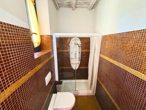 a bathroom with a toilet and a glass shower at Nonna Nara Bed & Breakfast in Grosseto