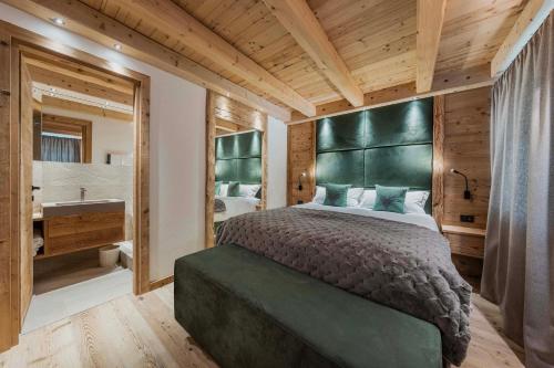 a bedroom with a large bed and a bath room at Chalet Socrepes - Dolomiti Skyline in Cortina dʼAmpezzo