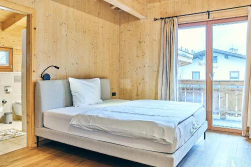 a bedroom with a bed and a large window at Chalet - Apartments Joel in Leutasch